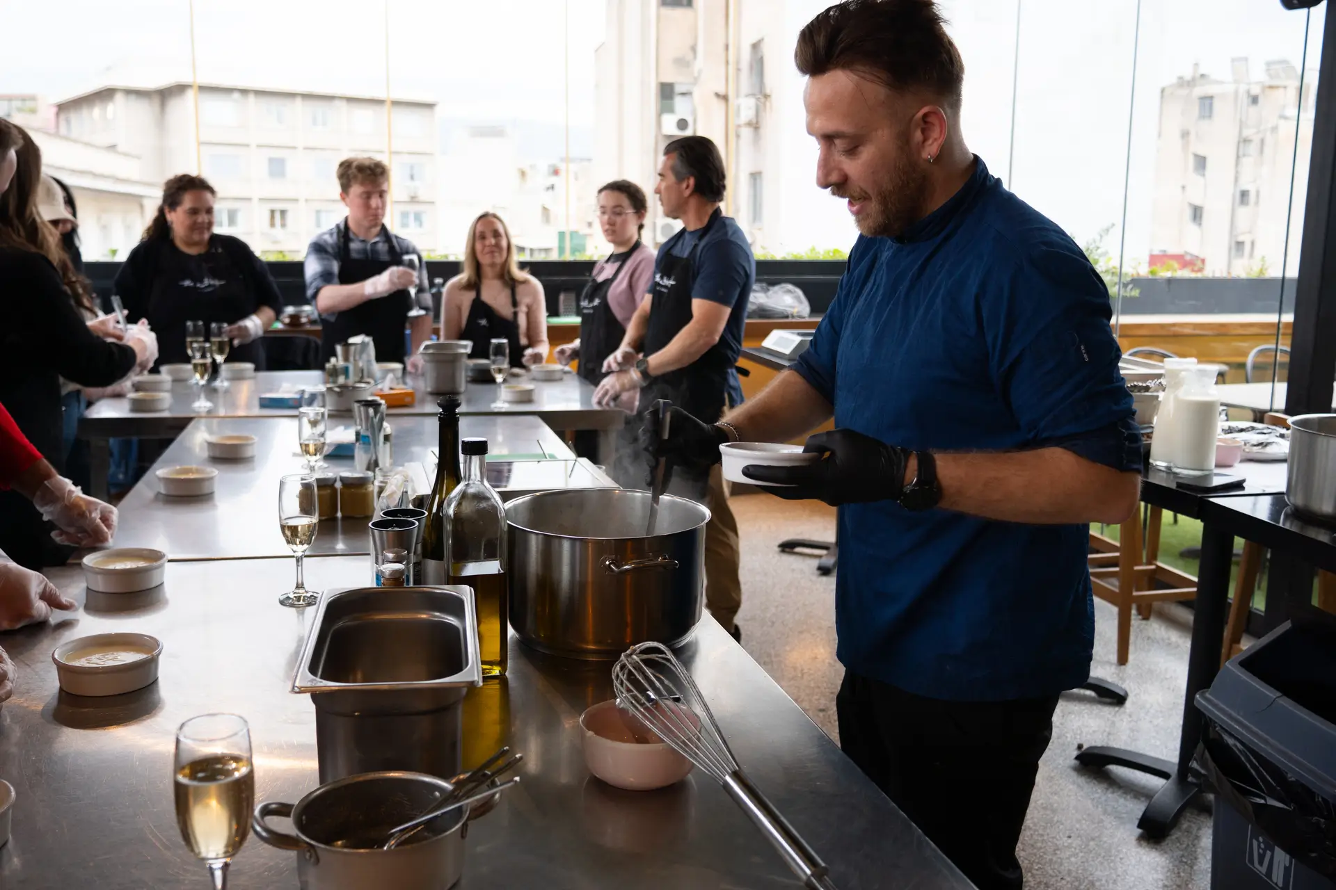 Chef Spyros teaching the class — hands-on cooking session at The Artist Athens