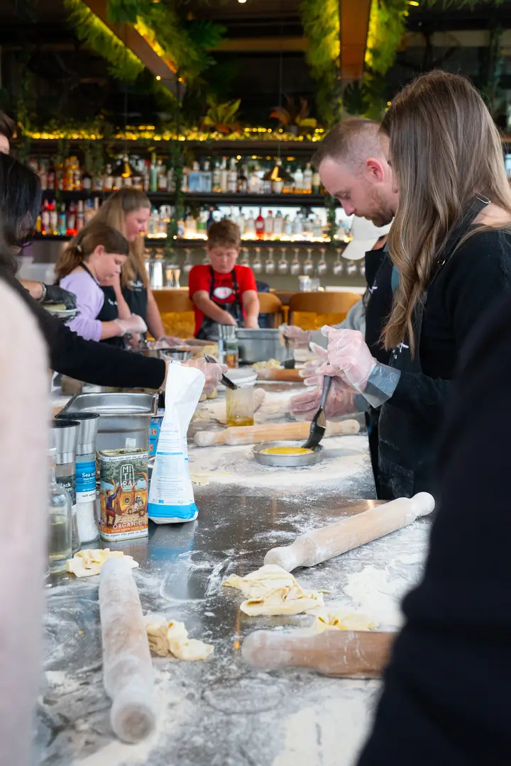 Everyone rolling phyllo dough by hand — spinach pie session in full swing