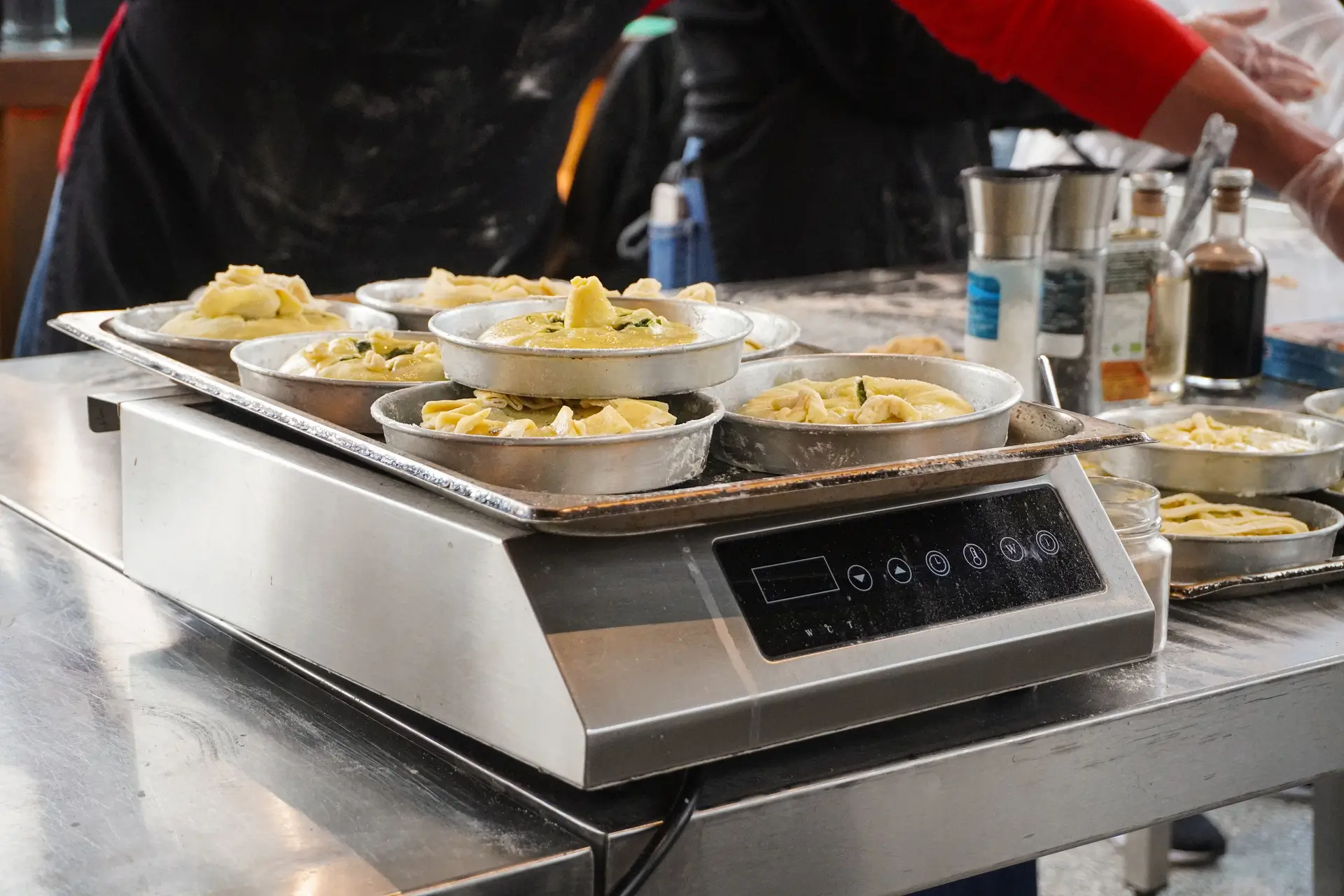 Individual galatopita pies ready on the induction — custard and phyllo perfection